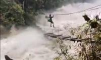 SEE: Man tries to cross raging river on wooden bridge 