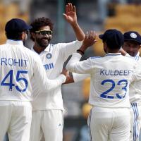 Ravindra Jadeja celebrates with teammates after taking the wicket of Glenn Phillips.