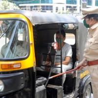 A cop stops an auto in Mumbai