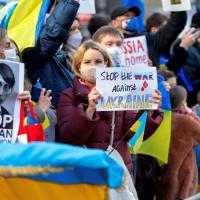 Ukrainians residing in Japan hold placards and flags during a protest rally