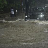 Vehicles ply a waterlogged street in Mumbai