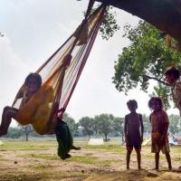Children playing on a makeshift swing. Representational image