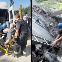 Rescuers evacuate a woman from under rubble in Donetsk