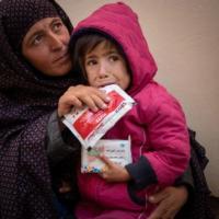 A mother with her child holding a UN food packet handout