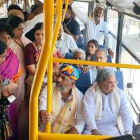 DK Shivakumar interacts with a conductor as he travels in a bus with CM Siddaramaiah
