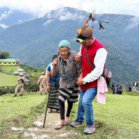 An elderly voter makes her way to a polling booth in Arunachal
