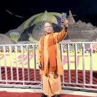 Yogi Adityanath takes a selfie with a sand art sculpture