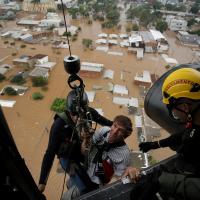 A man is rescued after the floods in Canoas, Brazil, May 4, 2024/Renan Mattos/Reuters