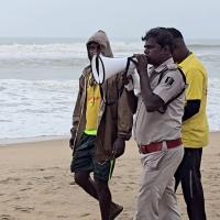 A policemen asks people to evacuate from Puri