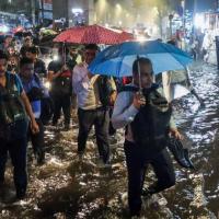 Harrowed commuters wade through a road in Ghatkopar