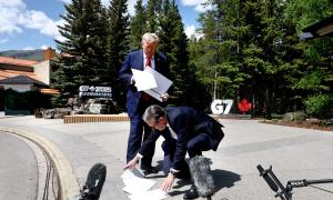 Why Is Britain's PM At Trump's Feet?