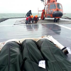 AirAsia QZ8501: First bodies returned to airport; bad weather hampers recovery of wreckage