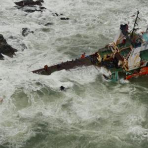 Navy ships rescue 146 from barge; aerial search on