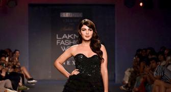 Black magic! Rhea casts a spell in layered gown