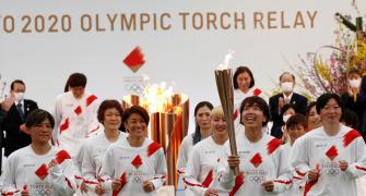 Smiles but no cheers as Olympic torch relay gets going