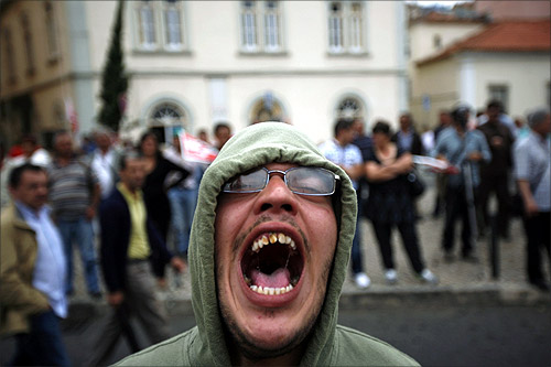 A demonstrator shouts slogans against the government during a protest opposite the Portuguese parliament in Lisbon.