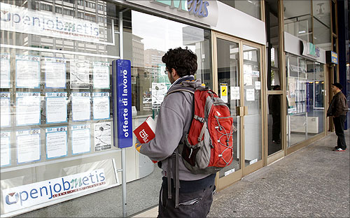 A man checks job offers outside a recruitment agency in downtown Milan.