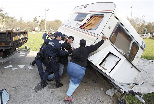 Mateus Silva, 25 and unemployed, and his wife Leonor, upturn their caravan while city police officers arrive to evict him in the Nossa Senhora de Fatima neighborhood.
