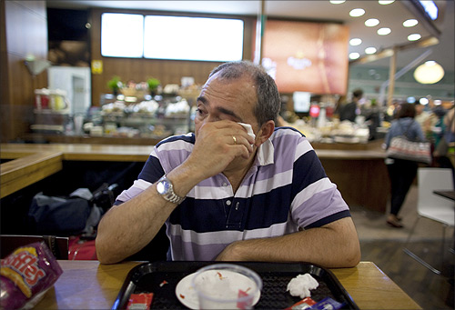Jose Manuel Abel, 46, cries as he waits to catch a flight to Munich at El Prat airport in Barcelona.