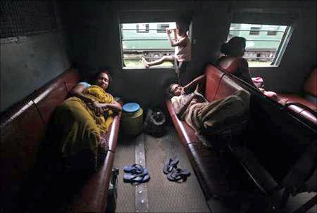 Passengers rest inside a train while waiting for the electricity to be restored at a railway station in Kolkata.
