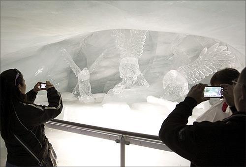 Tourists take pictures of ice sculptures in the Ice Palace glacier cave at the Jungfraujoch.
