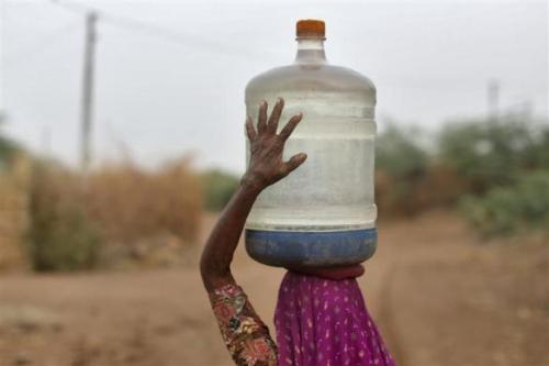 A village woman carries a container filled with drinking water supplied by the government-run water tanker at Charanka village in Gujarat.