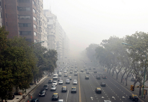 Cars drive through Del Libertador avenue amidst foggy conditions in downtown Buenos Aires.