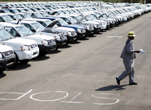 A worker walks near a row of cars at Nissan's manufacturing plant in Rosslyn, outside Pretoria, South Africa.