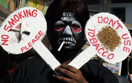 A man holds placards during an anti-tobacco awareness campaign.