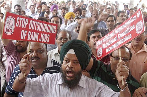 A bank employee shouts slogans while holding placards at a rally during a two-day strike in Chandigarh.