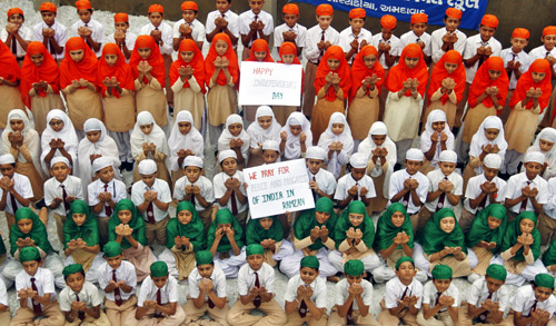 School children dressed in tri-colours of India's national flag, offer prayers on the eve of the country's Independence Day celebrations in Ahmedabad.