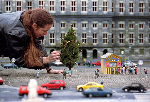 A worker at the miniature city of Madurodam decorates a Christmas tree with in the surroundings of the Royal palace on the Dam in Amsterdam.