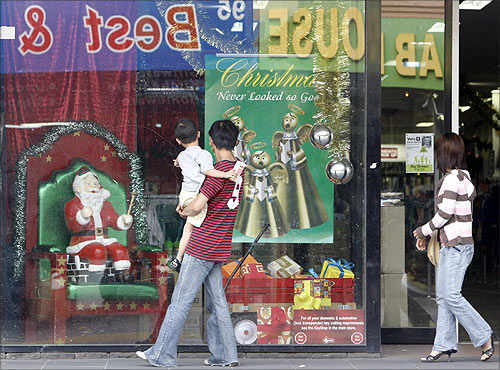 A family walk past a Christmas window display at a department store in suburban Melbourne.