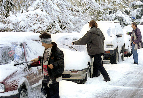 Residents remove snow from their cars after heavy snowfalls in Zurich.
