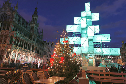 A traditional Christmas tree (front C) is seen near an illuminated steel installation at Brussels' Grand Place.