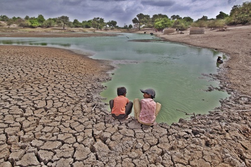 Children wash their hands in a partially dried out pond at Badarganj village, in Gujarat.
