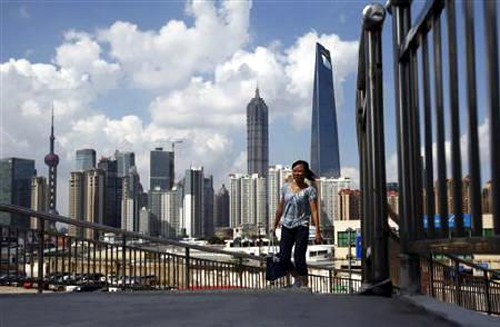 A woman walks on a bridge near the Pudong Lujiazui financial area in Shanghai.