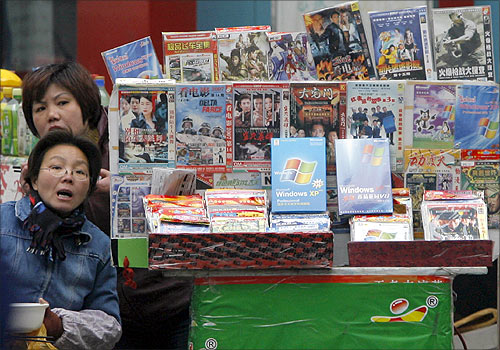 Vendors have their lunch at a stall selling pirated DVDs and software in Nanjing.
