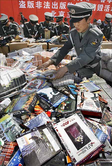 Chinese security officers prepare to destroy pirated DVDs and software during a ceremony in Beijing.