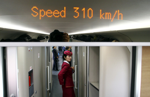 An attendant stands inside a high-speed train during an organized experience trip from Beijing to Zhengzhou, as part of a new rail line.