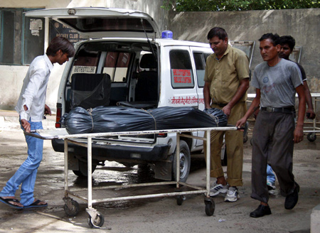 Hospital staff move the covered body of Awanish Kumar Dev, human resources manager at Maruti Suzuki plant in Manesar, from a hospital morgue in Gurgaon.
