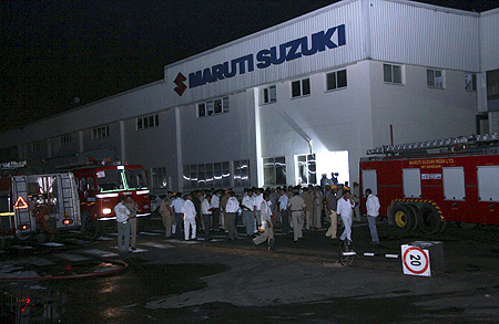 Police and firefighters are seen at the Maruti Suzuki's plant after a clash in Manesar.