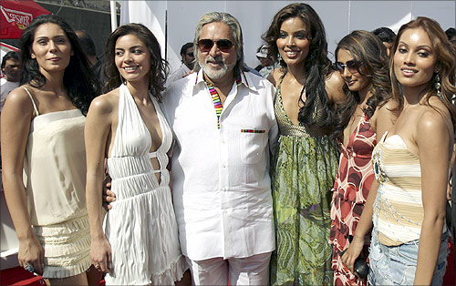 Chairman of United Breweries group Vijay Mallya (C) poses with models featured in Kingfisher's new Swimsuit Special 2007 calendar at a function in Mumbai.