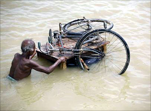 A man transports his bicycle through a flood-hit area of Darbhanga district, about 200 km north from Patna.