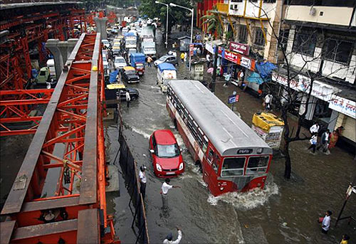 Floodwaters bog down traffic beside a bridge under construction after heavy rains swamped Mumbai.