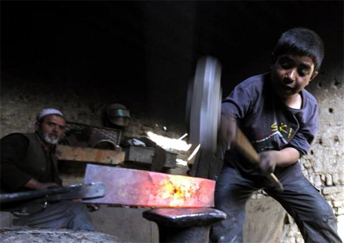 Afghan boy Abdul Wahab works in a blacksmith's shop in Kabul, Afghanistan.