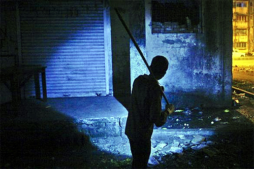 Waseem Sheikh, 12, holding an improvised stick searches for rats with the help of a torch outside a residential complex in Mumbai.