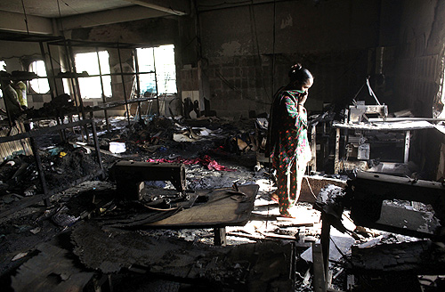 A worker visits a burnt garment factory after a fire which killed more than a hundred people in Savar.