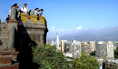 Tourists take in the view of the Andes Mountains from Santa Lucia Hill in downtown Santiago.