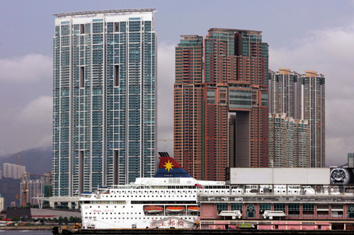 A cruise ship parks in front of two of Hong Kong's most luxurious high-rise residential buildings.